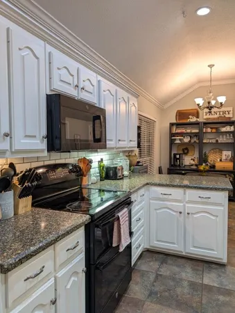 a kitchen with granite countertop a stove sink and cabinets