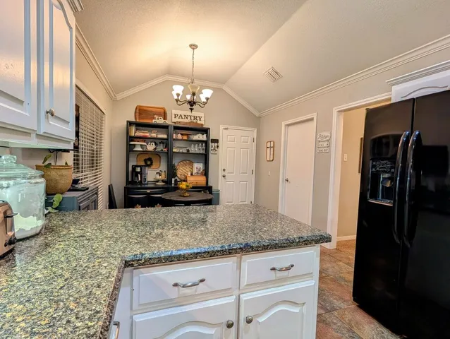 a view of a kitchen with granite countertop stainless steel appliances a refrigerator and a counter top space