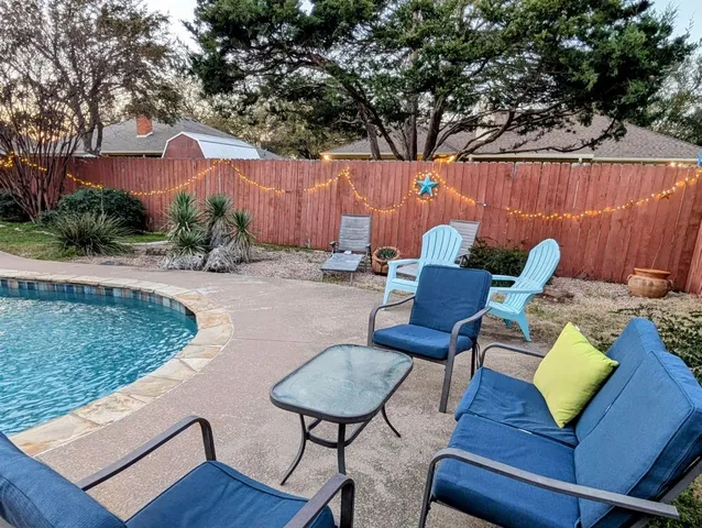 a swimming pool with outdoor seating and yard
