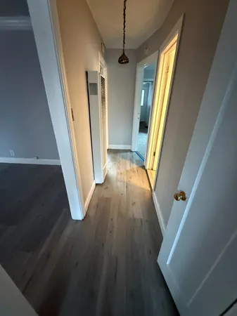 a view of a hallway with wooden floor and stairs