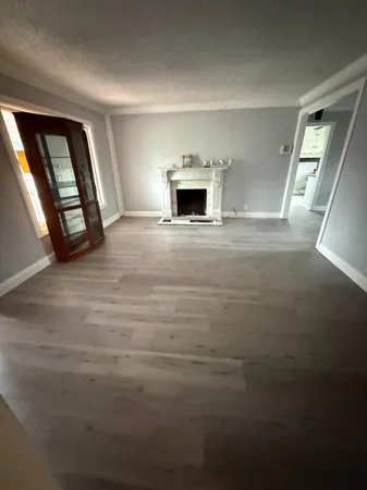 en empty room with windows and fireplace