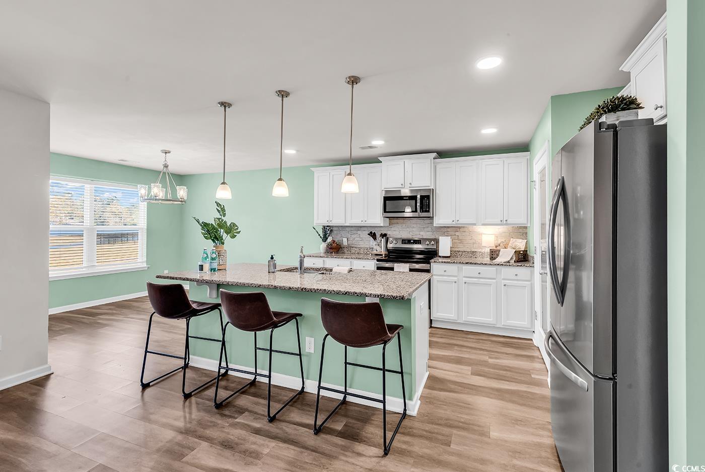 623 Burnt Ash Drive Longs, SC 29568 - Photo 4 of 35 Kitchen featuring stainless steel appliances, a breakfast bar, backsplash, pendant lighting, and an island with sink