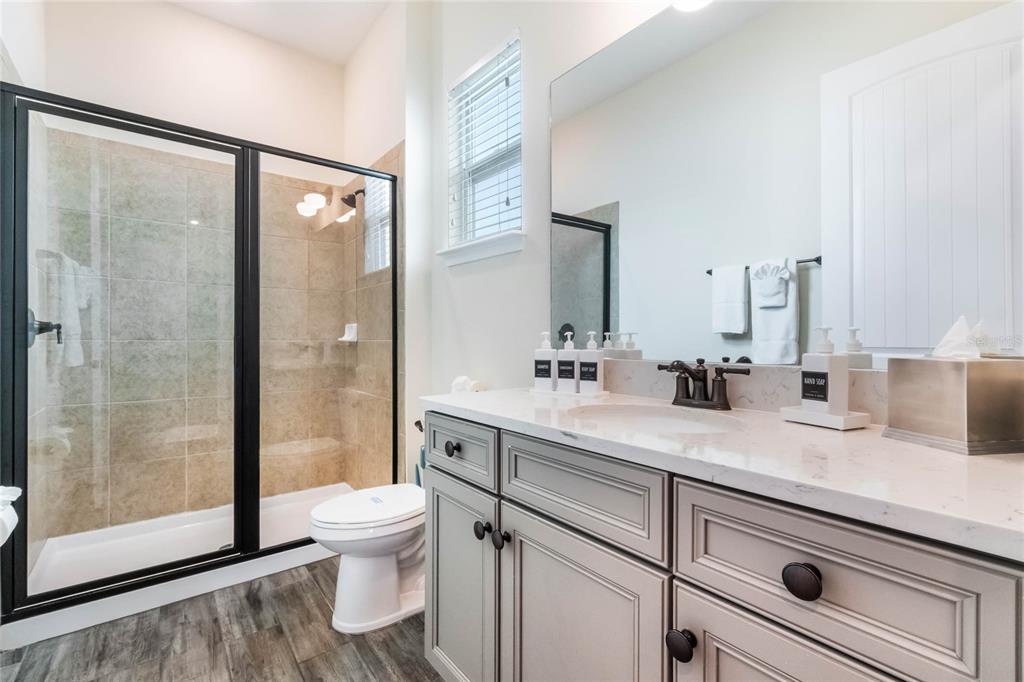8008 Sandy Toes Way Kissimmee, FL 34747 - Photo 15 of 21 a bathroom with a granite countertop sink toilet a mirror and shower