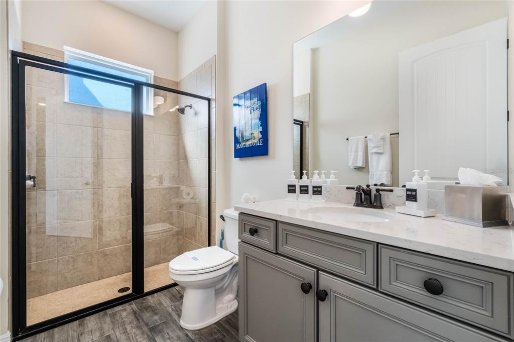 8008 Sandy Toes Way Kissimmee, FL 34747 - Photo 17 of 21 a bathroom with a double vanity sink toilet mirror and shower