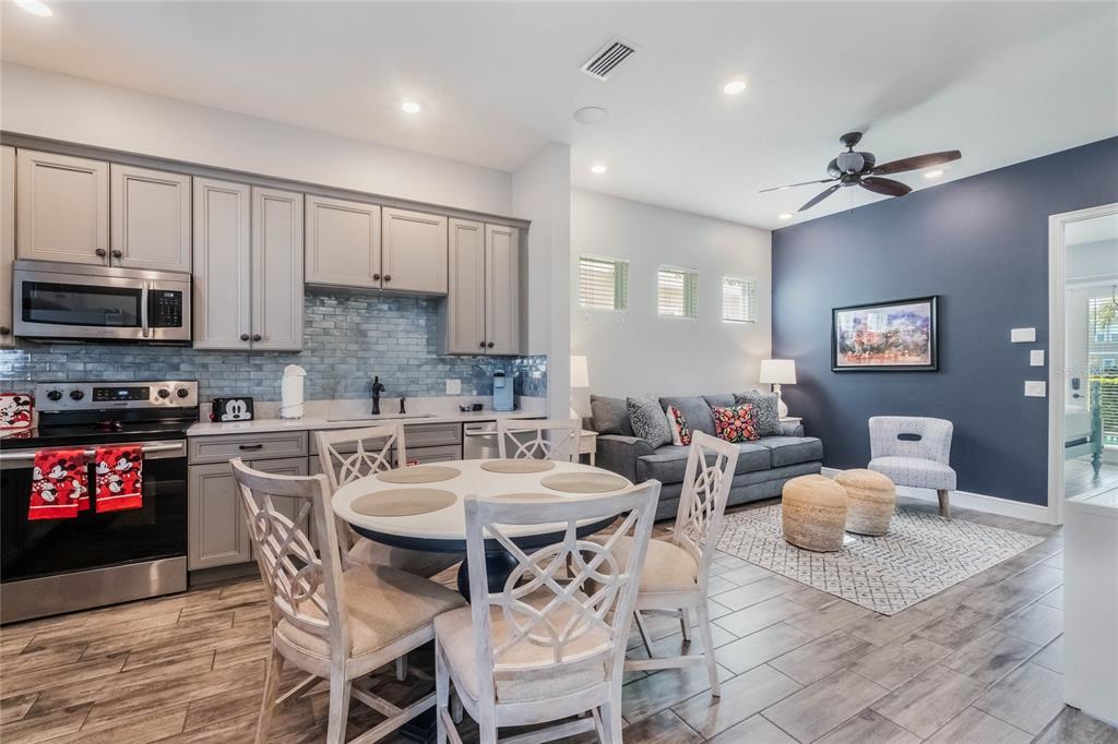 8008 Sandy Toes Way Kissimmee, FL 34747 - Photo 4 of 21 a view of a dining room with furniture a kitchen and chandelier