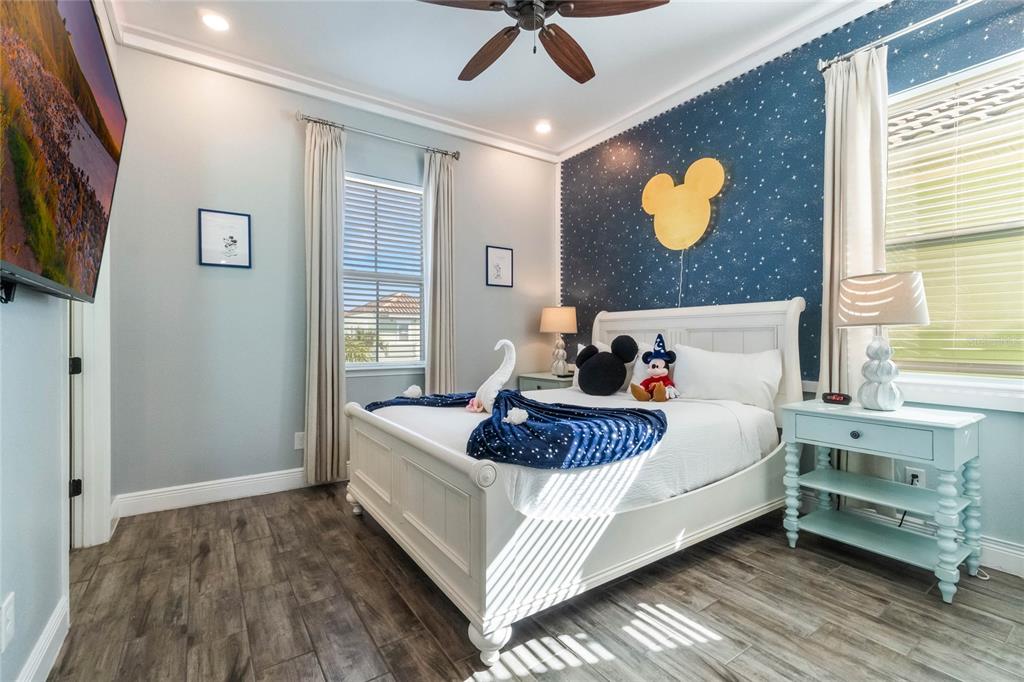 8008 Sandy Toes Way Kissimmee, FL 34747 - Photo 8 of 21 a spacious bedroom with a bed and a chandelier