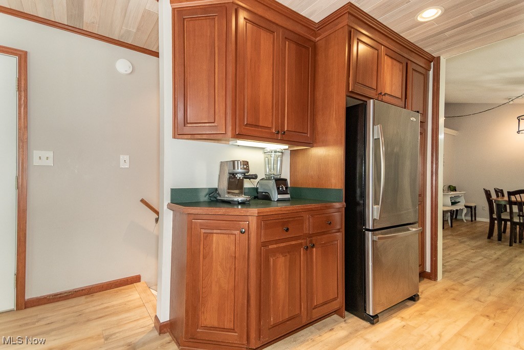 33 Woodside Road Chagrin Falls, OH 44022 - Photo 16 of 48 Kitchen with freestanding refrigerator, light wood-style floors, brown cabinetry, and dark countertops