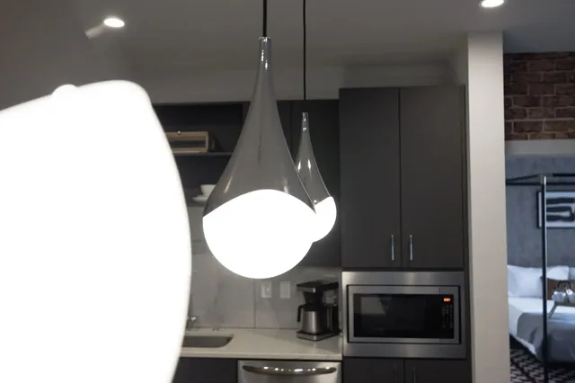 a living room with furniture kitchen view and a chandelier