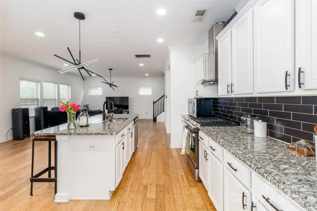 a kitchen with stainless steel appliances kitchen island granite countertop a sink and cabinets