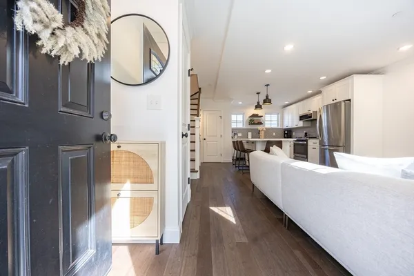 a living room with stainless steel appliances kitchen island granite countertop furniture and a fireplace