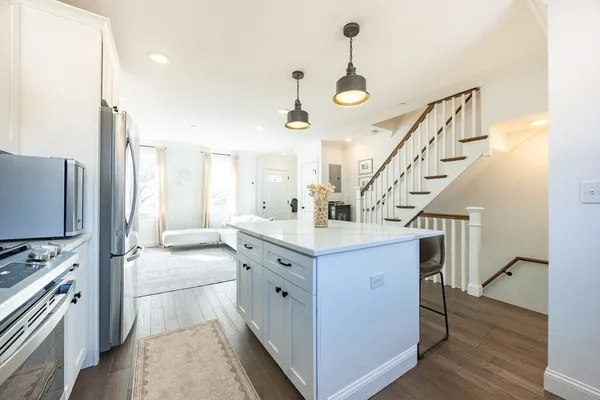 a kitchen with granite countertop a stove a sink and a refrigerator