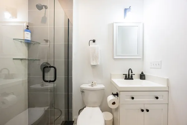 a bathroom with a toilet sink vanity and mirror