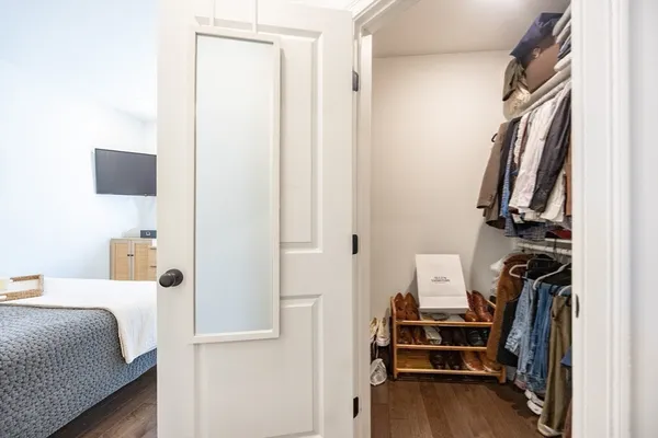 a view of walk in closet with clothes and shoes