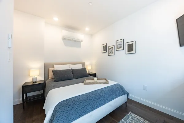 a bedroom with a bed and wooden floor