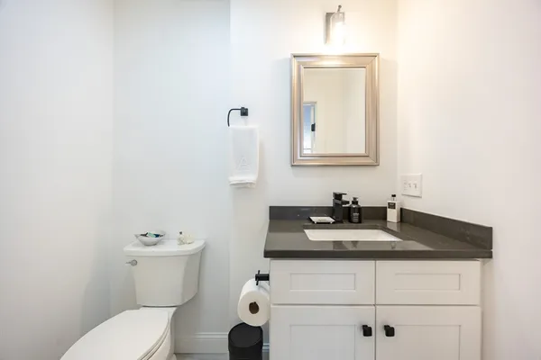 a bathroom with a granite countertop toilet sink and mirror
