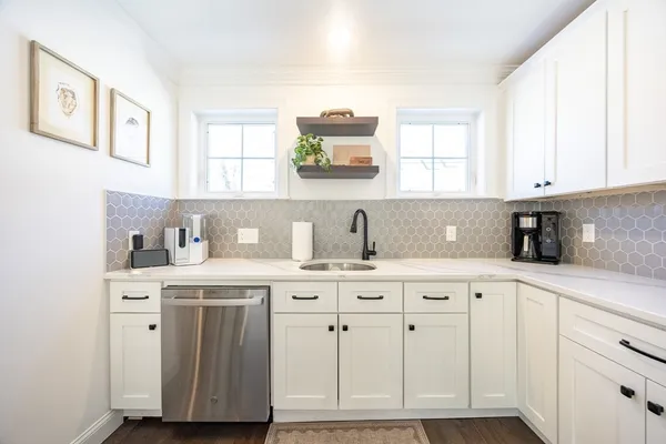 a kitchen with cabinets appliances a sink and a window