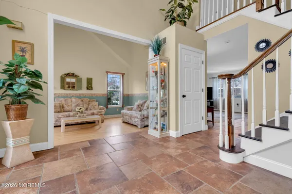a kitchen with stainless steel appliances kitchen island granite countertop a refrigerator a stove and white cabinets with wooden floor