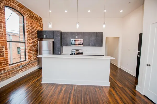 a view of kitchen with stainless steel appliances granite countertop a refrigerator a sink and a stove
