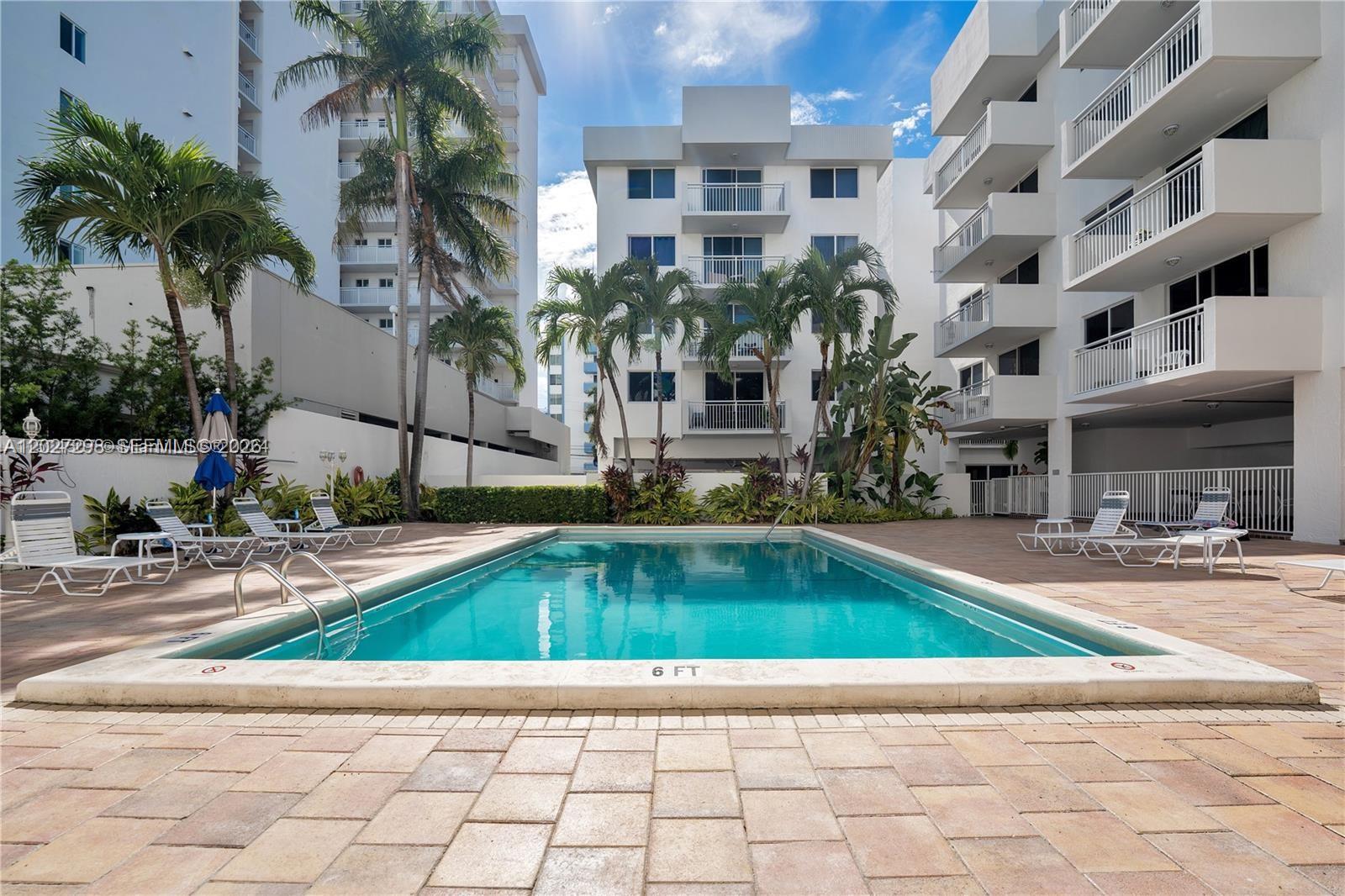 1665 Bay Road, Unit 322 Miami Beach, FL 33139 - Photo 18 of 24 a view of a swimming pool with a lounge chairs