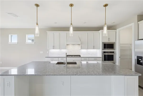 a kitchen with kitchen island counter space a sink and appliances