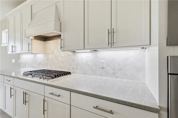 a kitchen with white cabinets and a stove
