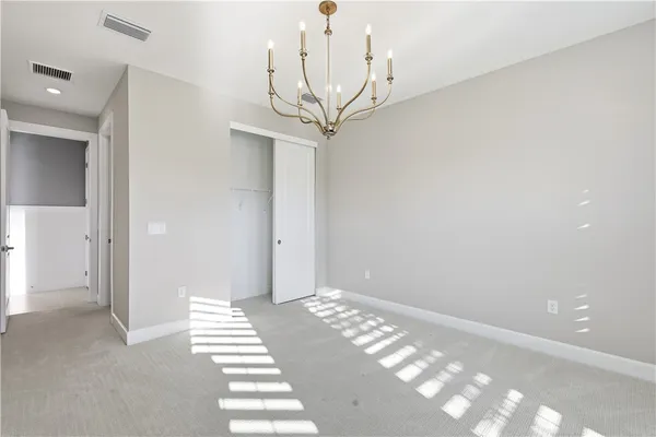 a view of a hallway with stairs and chandelier