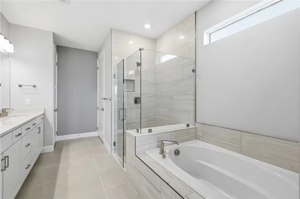 a bathroom with a tub a sink shower and mirror