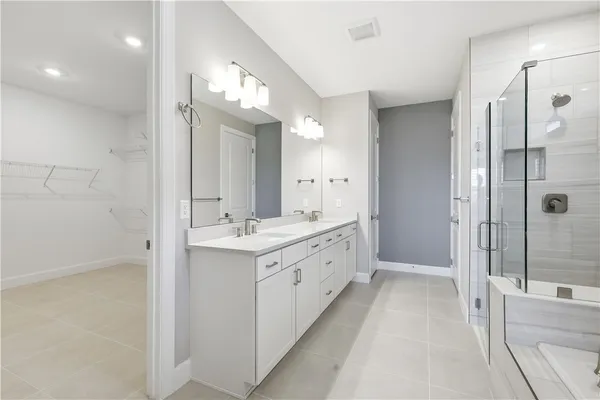 a bathroom with a double vanity sink mirror and shower