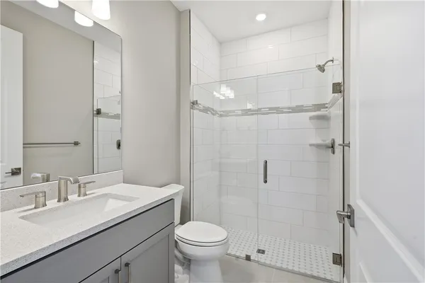 a bathroom with a granite countertop sink toilet and shower