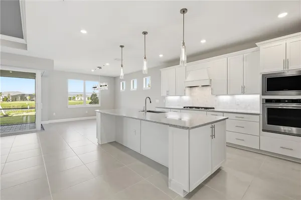 a kitchen with granite countertop a sink a counter space appliances and cabinets