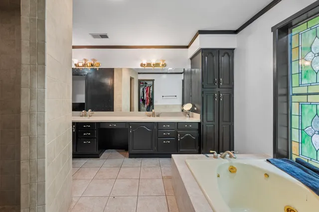 a spacious bathroom with a tub sink and mirror