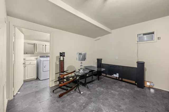 a view of a workspace with furniture and a window