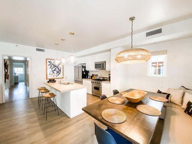 136 Georgetown Avenue, Unit 2C 5 Inlet Beach, FL 32461 - Photo 11 of 18 a open dining room with stainless steel appliances furniture a chandelier and a table