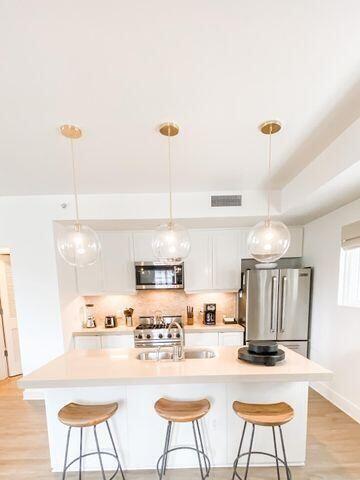 136 Georgetown Avenue, Unit 2C 5 Inlet Beach, FL 32461 - Photo 18 of 18 a kitchen with stainless steel appliances wooden floor dining table and chairs