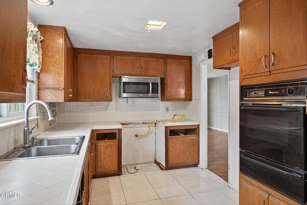 1430 Huntswood Way Oxnard, CA 93030 - Photo 5 of 12 a kitchen with stainless steel appliances granite countertop a sink stove and refrigerator