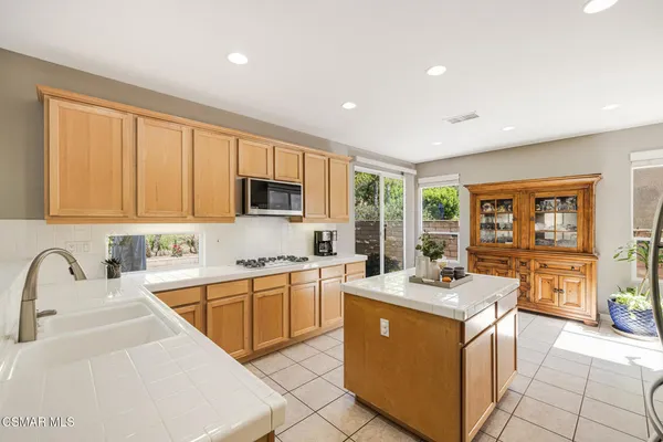 a kitchen with refrigerator cabinets and large window