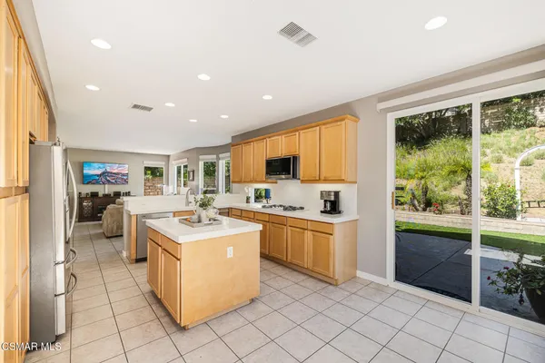 a kitchen with stainless steel appliances granite countertop a refrigerator sink stove microwave and cabinets