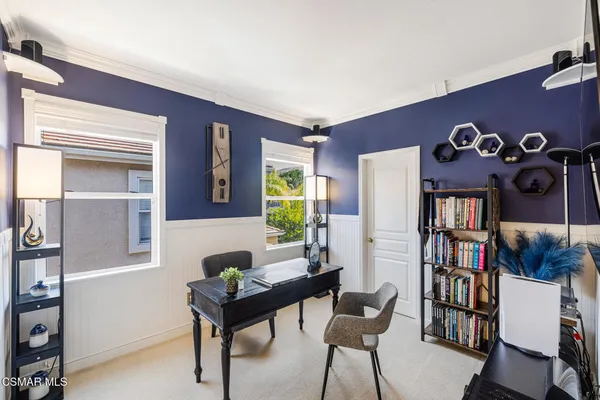 a bedroom with a bed a large window and dresser