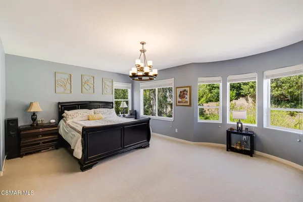 a spacious bedroom with a bed and a chandelier