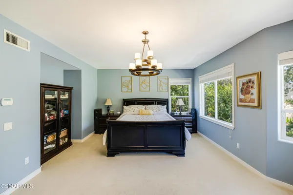 a bathroom with a bathtub a double vanity sink a window and a mirror