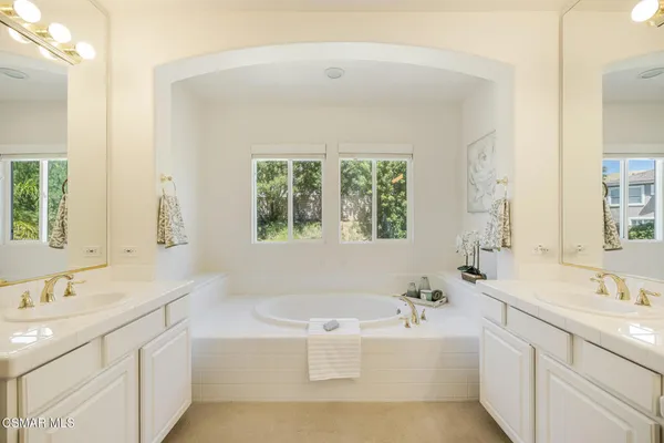 a bathroom with a sink vanity tub and a mirror