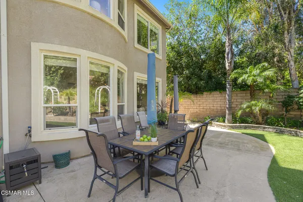 a view of a patio with couches table and chairs and potted plants