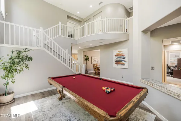 a room with pool table and potted plants