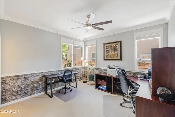 a view of a workspace with furniture and a window