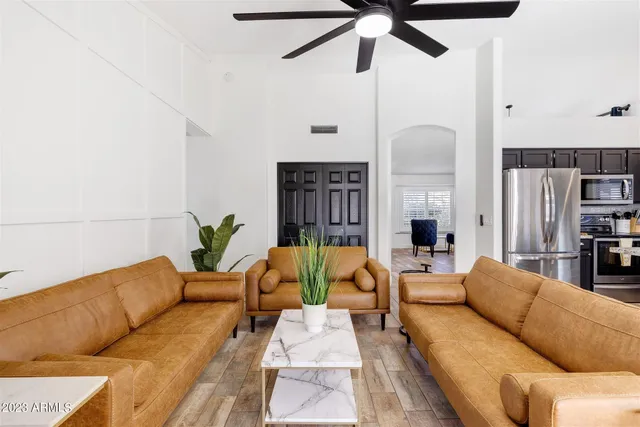 a living room with furniture kitchen view and a chandelier