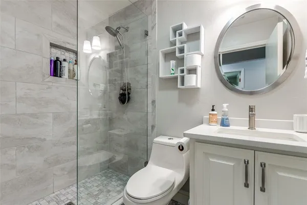 a bathroom with a toilet sink vanity and mirror