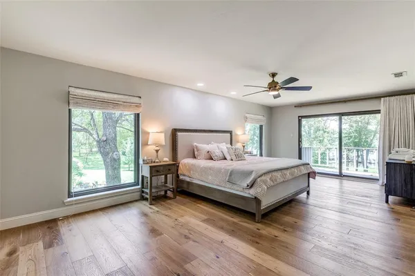 a bed sitting in a spacious bedroom next to a window