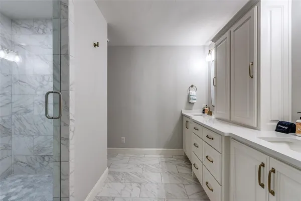 a bathroom with a double vanity sink a mirror and a shower