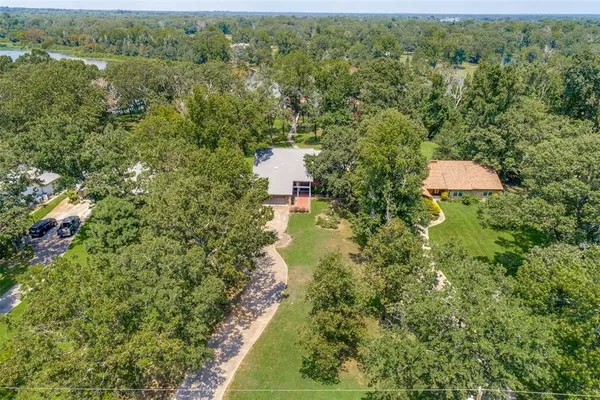 an aerial view of residential house with outdoor space and trees all around