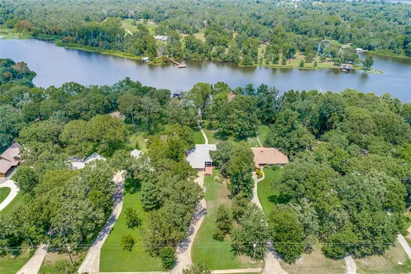 an aerial view of a house with a yard and lake view